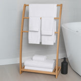 Bamboo towel rack with white towels in a bathroom setting