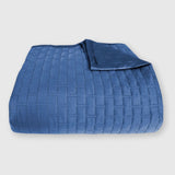 dark blue indigo bamboo quilted coverlet elegantly folded with brick pattern