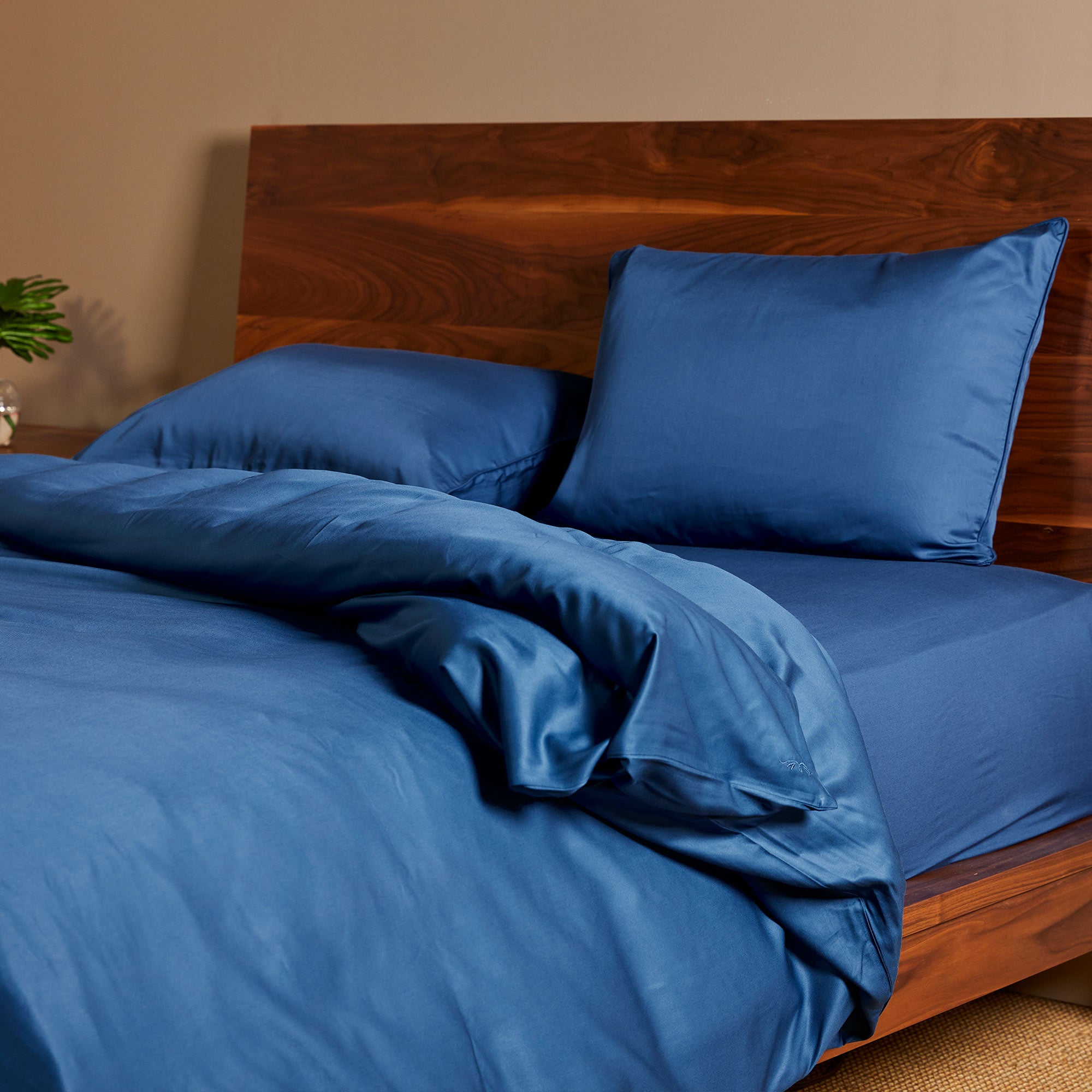 dark indigo blue bamboo duvet cover and standard shams on a bamboo bed frame
