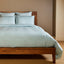 sky blue silky bamboo duvet cover on a bamboo bed frame with standard sham pillows 