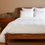 white silky bamboo duvet cover on a bamboo bed frame with standard sham pillows 