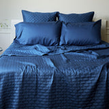 indigo dark blue quilted bamboo coverlet on a bed with pillows
