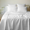 white quilted bamboo coverlet on a bed with pillows
