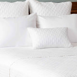 white bamboo quilted coverlet with decorative pillows on a bed