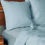 sky quilted bamboo euro shams brick pattern on an elegant bed