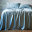 sky blue bamboo sheet set and pillows on an elegant bed