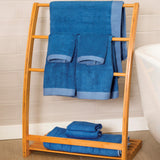 8pc dark blue indigo bamboo towels hanging on a bamboo rack in a bathroom