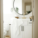 white bamboo bath towel hanging on edge of sink counter in bathroom