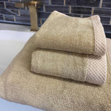 tan beige champagne bamboo 3pc towel set stacked on bathroom counter