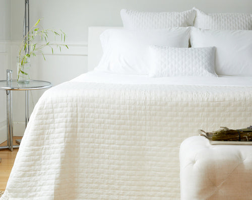 ivory bamboo coverlet on a bed in pretty bedroom