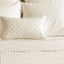 ivory quilted bamboo decorative pillow on a bed with coverlet 