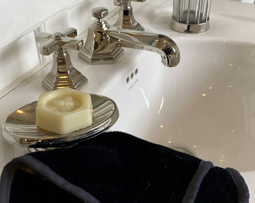 black bamboo facial washcloth on bathroom sink with soap