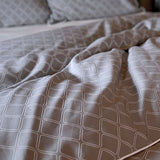 dark gray platinum and white geometric pattern duvet cover on bed 