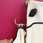 hooded bamboo baby towel hanging from a bathroom hanger