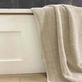 sand beige melange bamboo bath sheet hanging over a tub