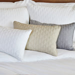 melange bamboo decorative pillows in 3 colors laying on a bed