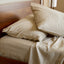 sand beige melange bamboo pillows laying on a bed with sheets and cozy