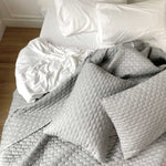 silver gray quilted melange bamboo coverlet and standard shams on a cozy bed