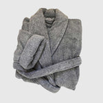 dark gray charcoal bathrobe folded up with waist tie laying over it