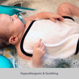 baby boy in infant tub with a baby washcloth covering his body