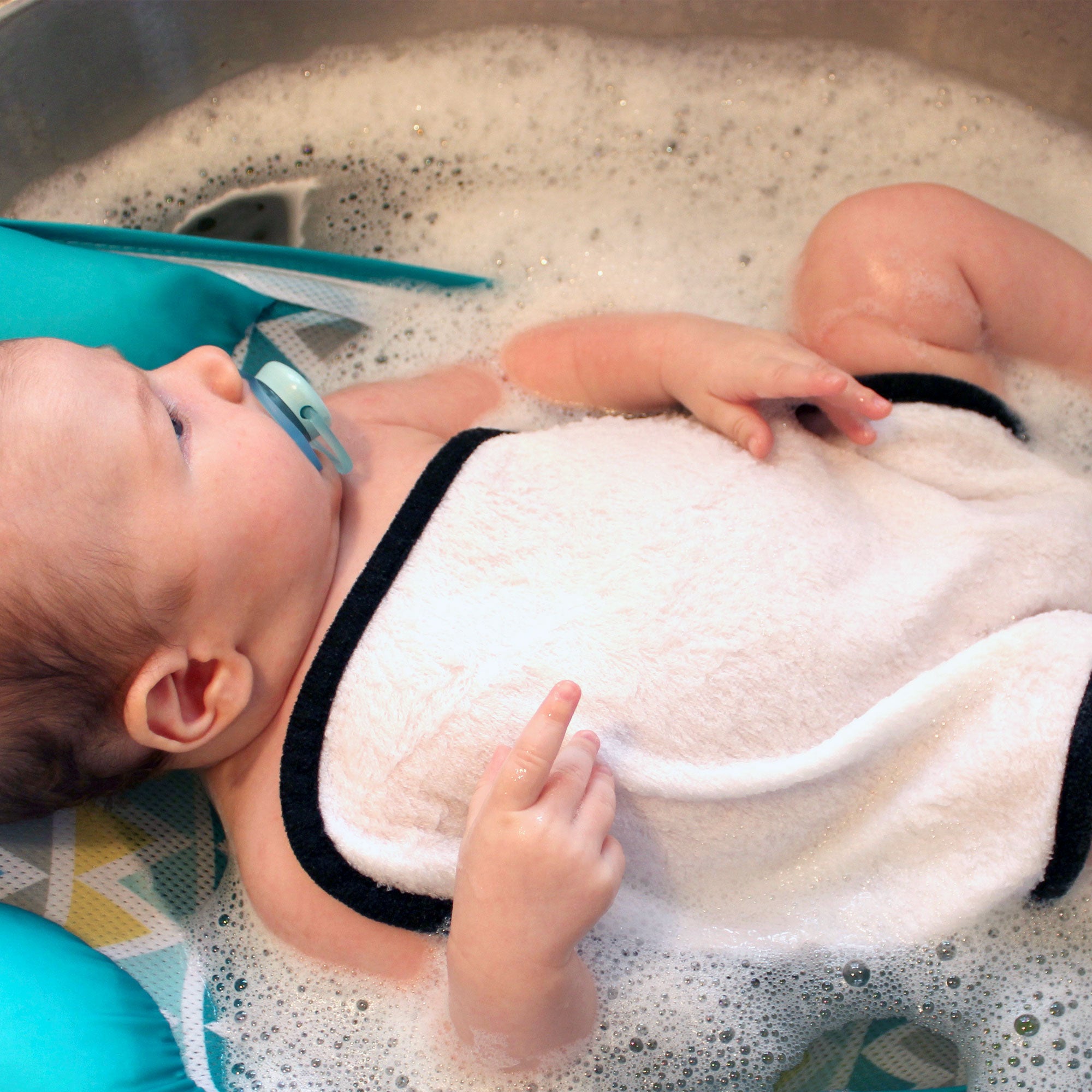 infant getting bath in tub with a bamboo baby washcloth