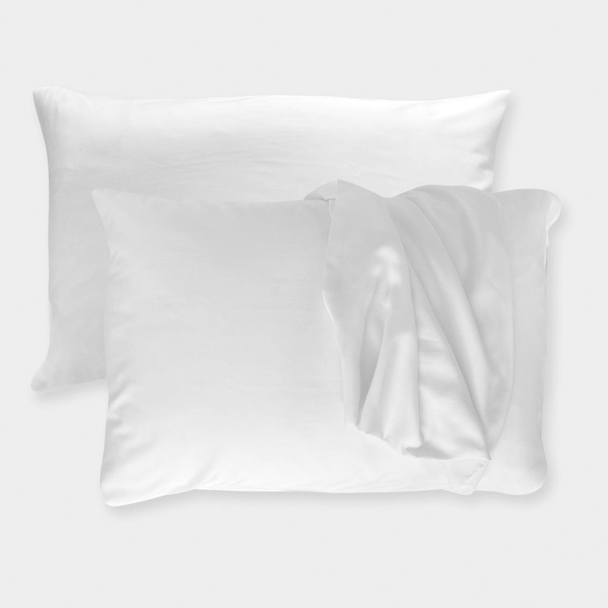 white bamboo pillowcases on pillows with one pillowcase draped over pillow