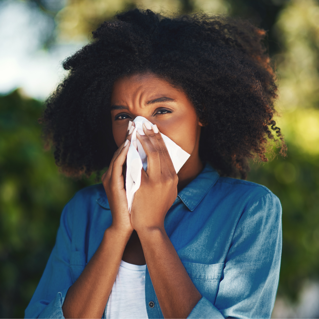 Woman sneezing into tissue