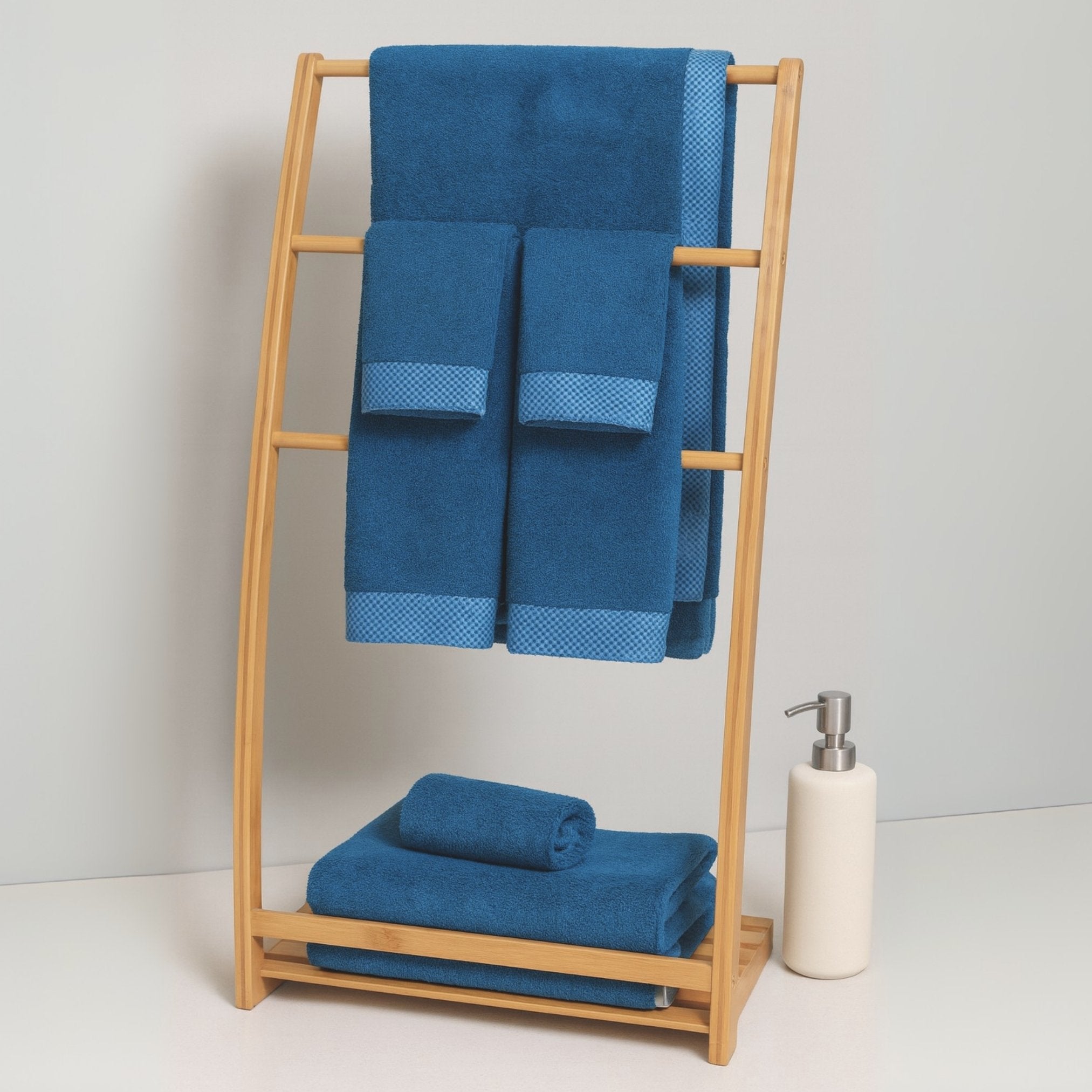 Blue towels on a wooden towel rack with a white background
