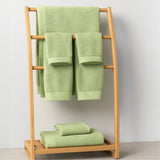 Green towels on a wooden towel rack against a white background