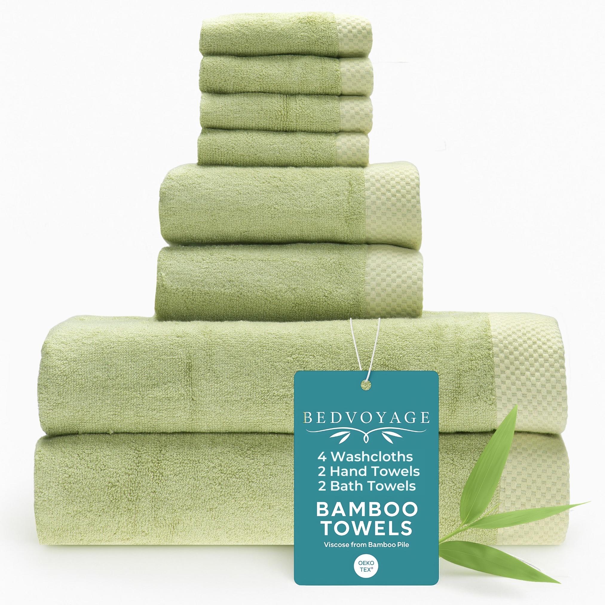 Stack of green bamboo towels with a 'Bed Voyage' tag on a white background