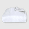 white bamboo quilted coverlet elegantly folded with brick pattern