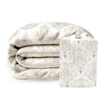 Folded patterned duvet comforter with matching pillow on a white background
