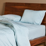 sky blue bamboo duvet cover and standard pillow shams on a bamboo bed frame