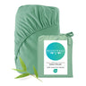 Green bamboo fitted sheet with packaging and leaf on a white background