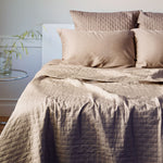 champagne beige quilted bamboo coverlet on a bed with pillows