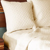 ivory quilted bamboo euro shams brick pattern on an elegant bed