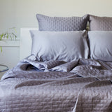 dark gray platinum quilted bamboo coverlet messy bed with pillows