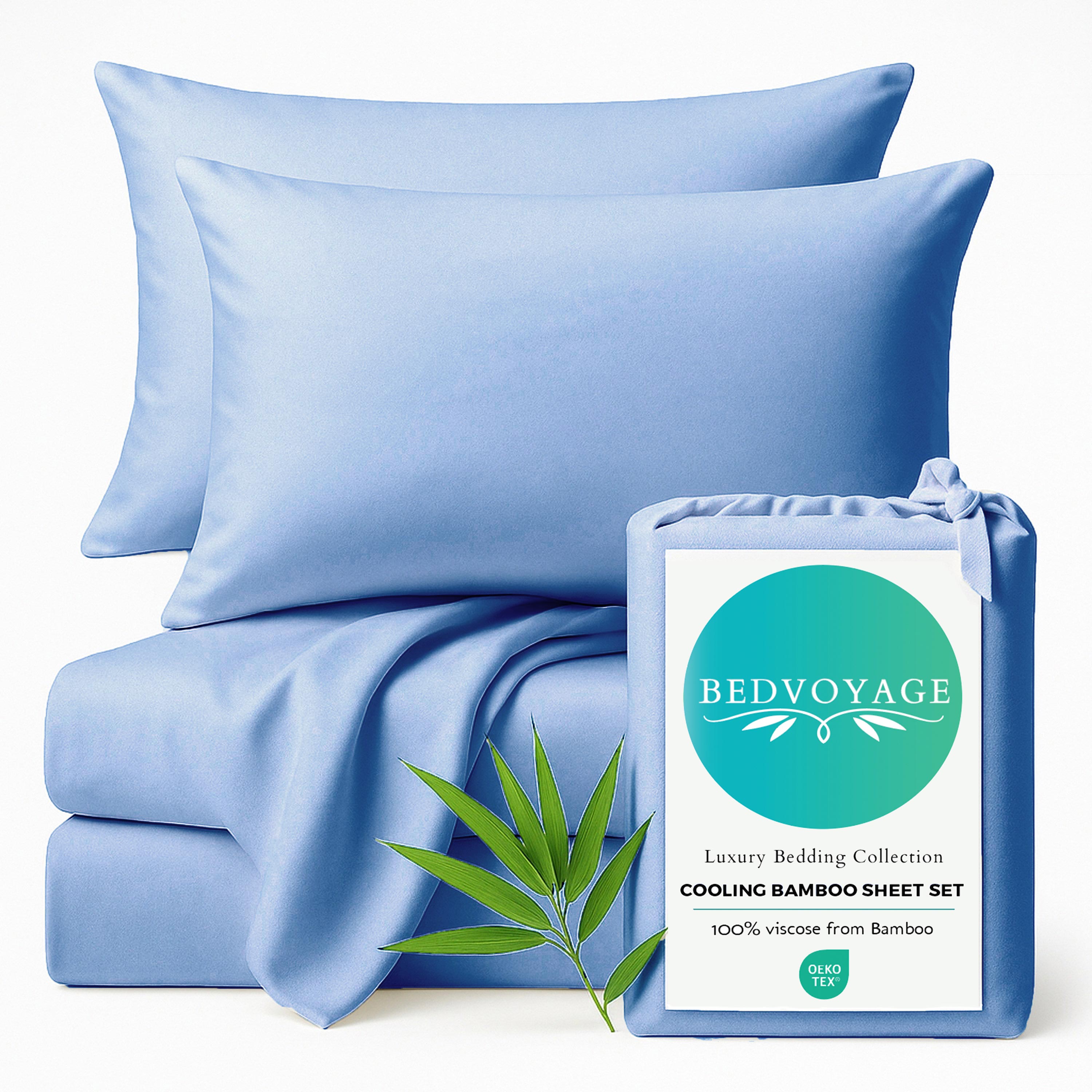 ocean blue bamboo bed sheets stack with pillows sitting on a white background with packaging bag and bamboo leaf 