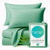 seaglass green bamboo bed sheets stack with pillows sitting on a white background with packaging bag and bamboo leaf 