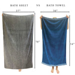 woman holding 2 towels 1 is a bath sheet and 1 is a bath towel to show size difference