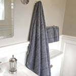 charcoal gray melange bamboo bath sheet and hand towel set hanging in a bathroom