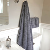 charcoal gray melange bamboo bath sheet and hand towel set hanging in a bathroom