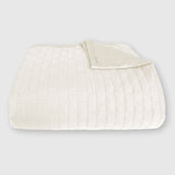 ivory bamboo quilted coverlet elegantly folded with brick pattern