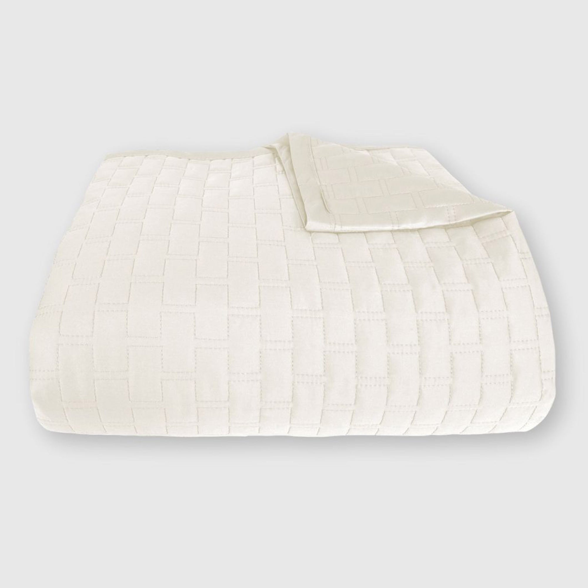 ivory bamboo quilted coverlet elegantly folded with brick pattern