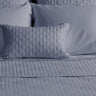 platinum gray quilted bamboo decorative pillow on a bed with coverlet 