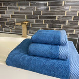 3piece indigo dark blue towel set stacked on a bathroom counter