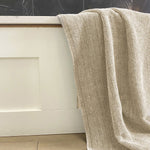 sand beige melange bamboo bath sheet hanging over a tub