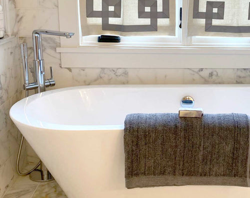 charcoal bath sheet hanging over tub