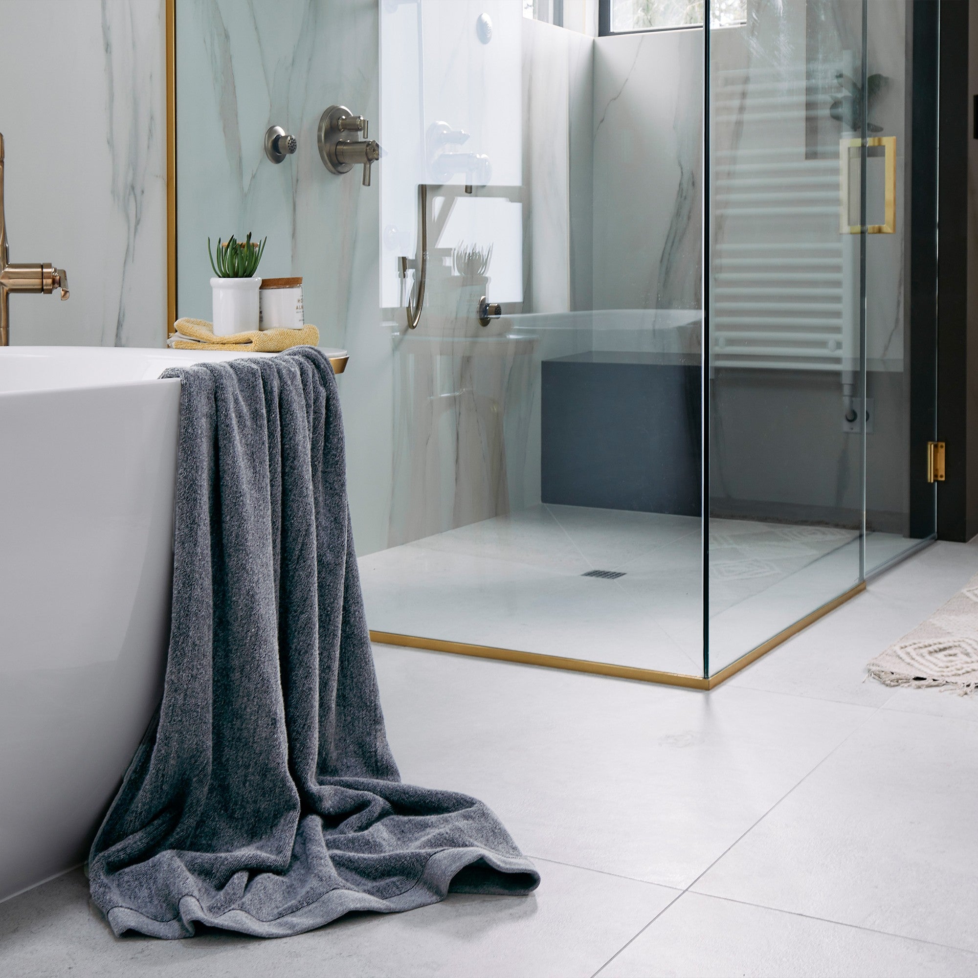 luxury bathroom with charcoal bath sheet hanging over tub