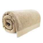 Rolled beige towel on a white background